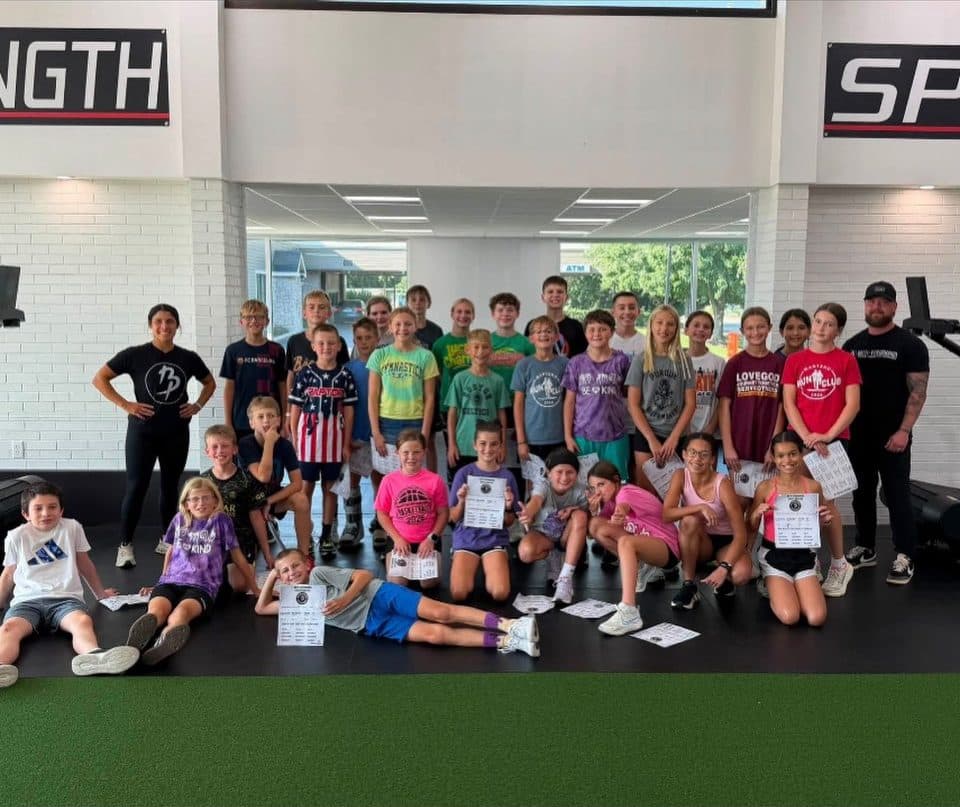 Group photo of about 35 young athletes with two Batti coaches