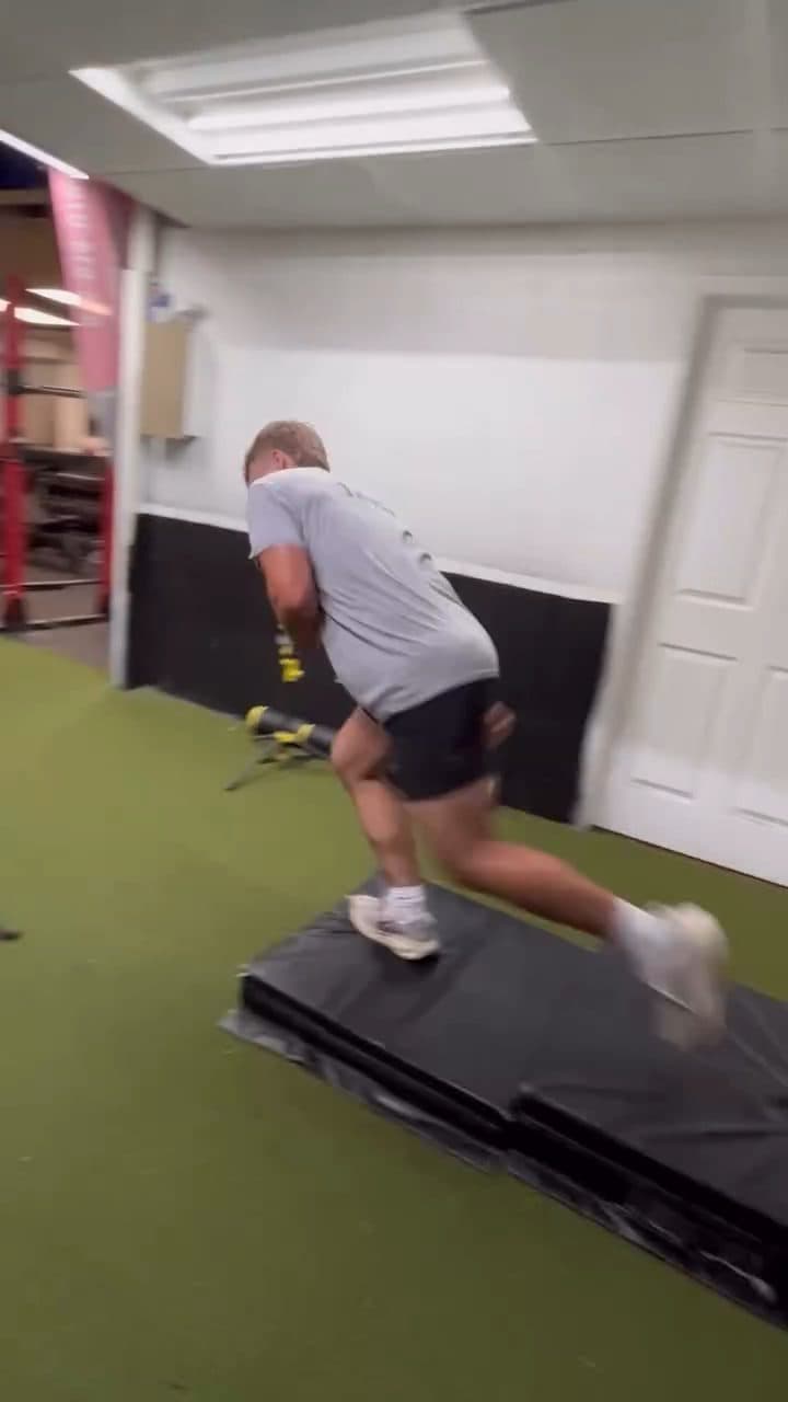 Athlete driving out of a start off the crash pad